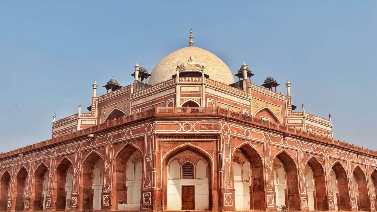 Delhi cityscape showing historic Mughal architecture and warm evening atmosphere